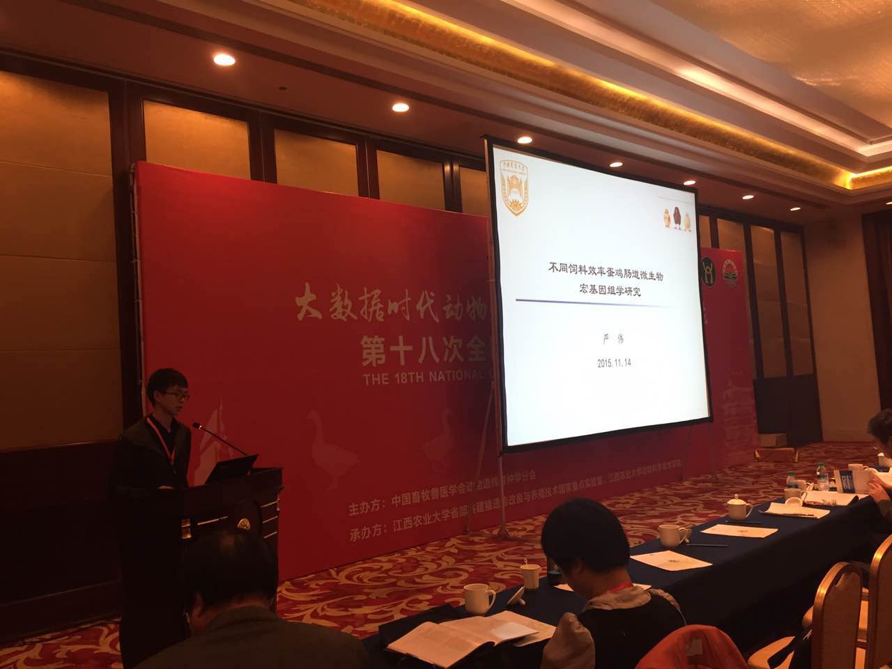 嚴偉老師正在演說報告內容，老師在左邊,中間是PPT